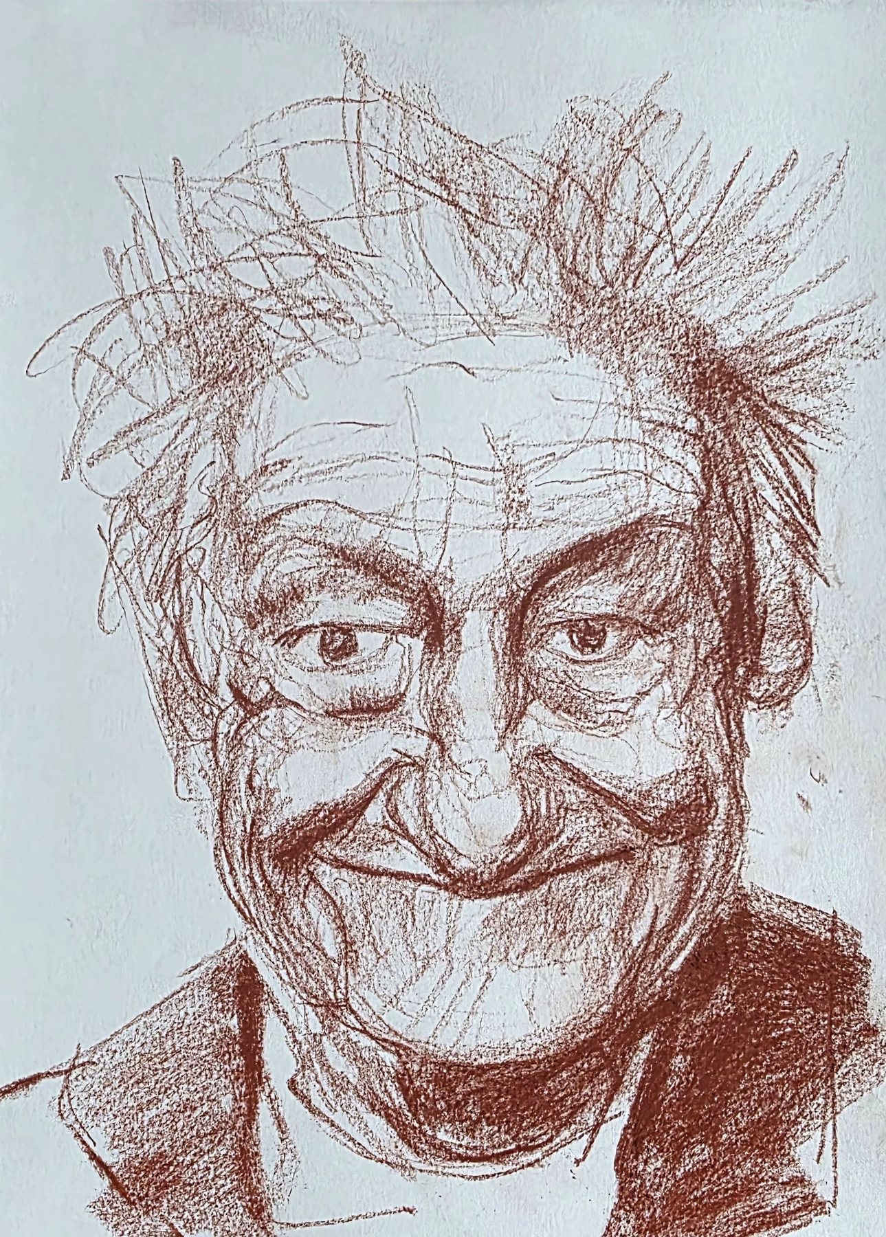 Red chalk portrait of an older man with wild hair, grinning